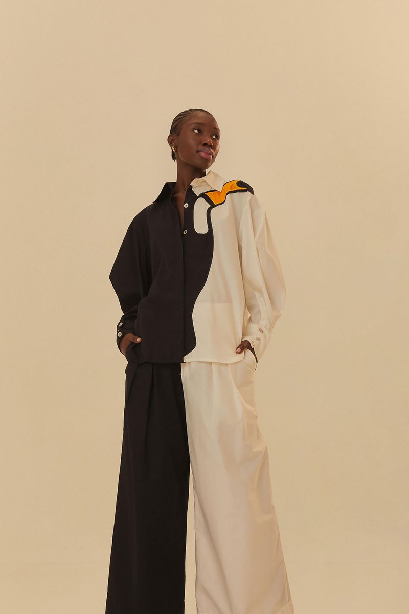 Modelo usando pantalón bicolor sastrería con diseño asimétrico en azul y blanco.