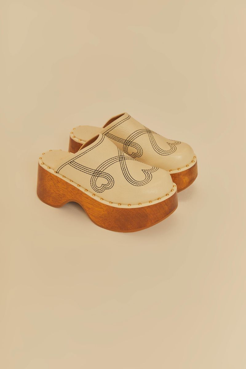 Tamanco plataforma bordado con detalles geométricos y base de madera.
