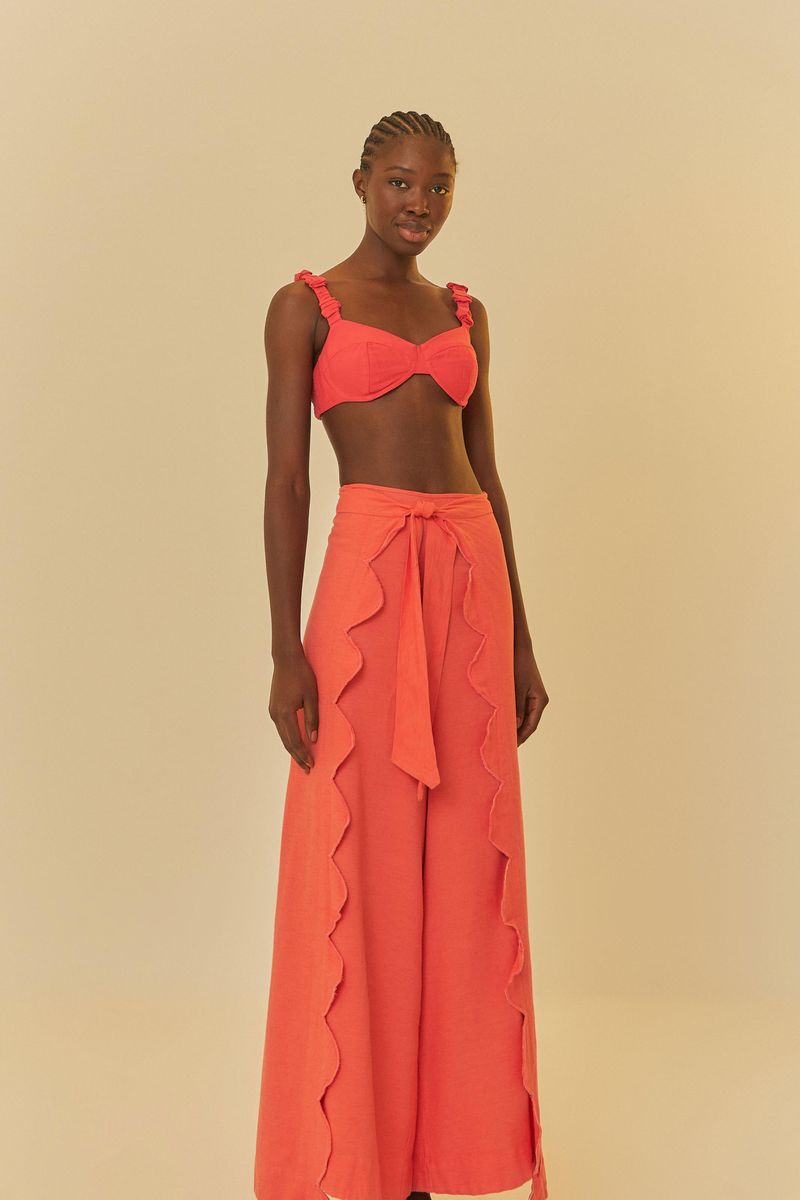 Modelo usando pantalón rosa con ajuste en la cintura y detalles verticales.