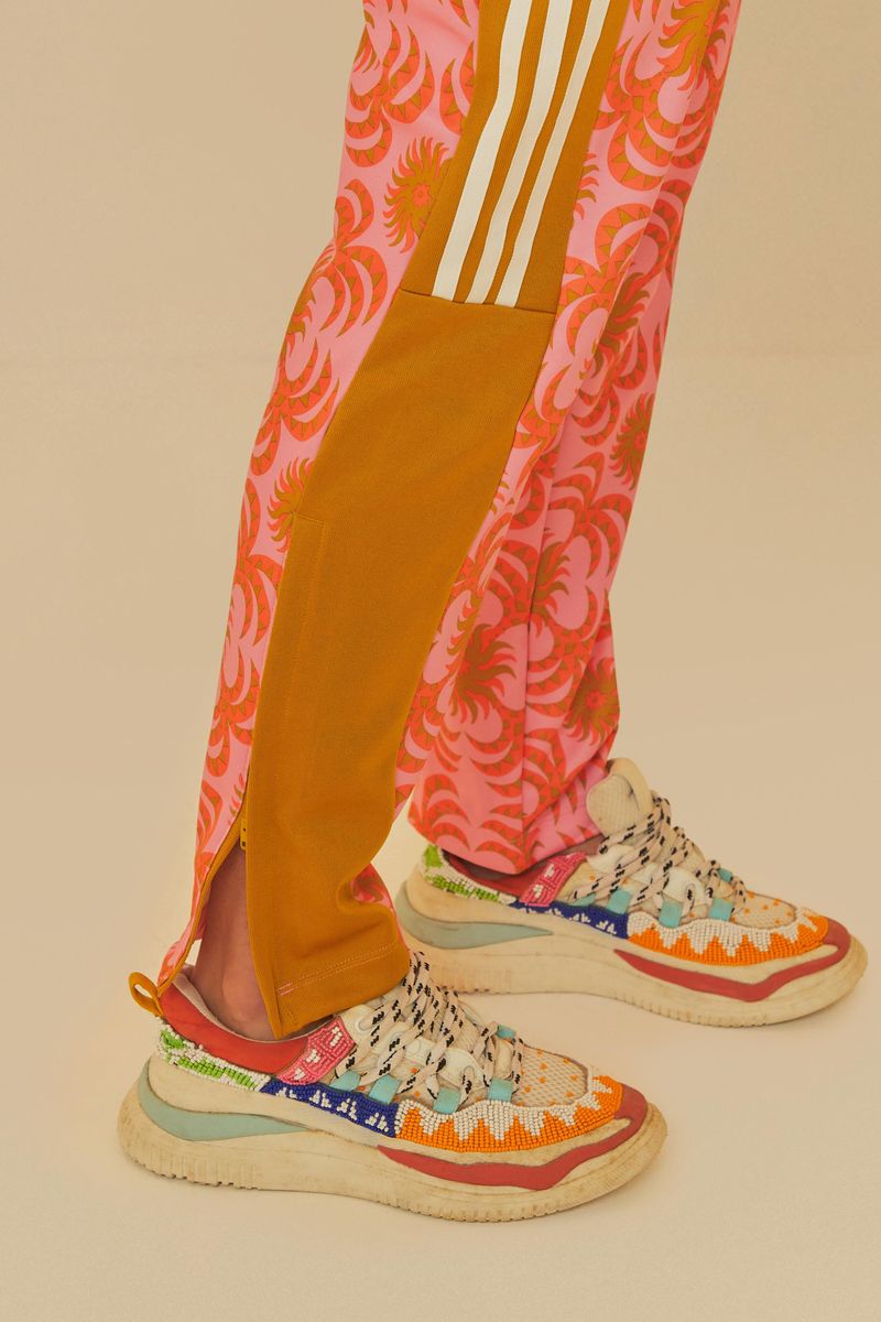 Detalle del pantalón Adidas Palm Flower Rosa, mostrando el acabado en el dobladillo y el patrón floral en rosa con detalles en amarillo.