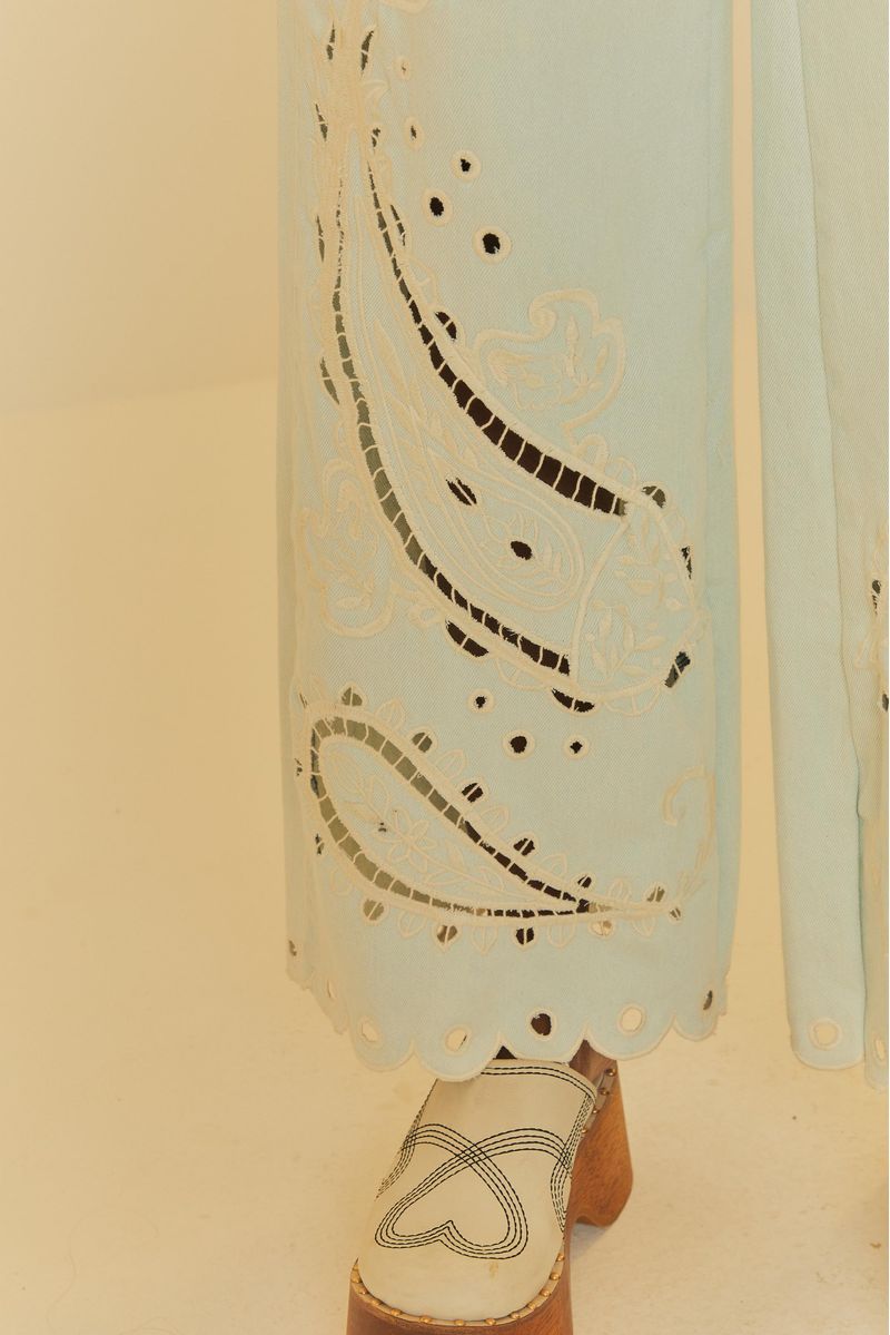Primer-plano-del-borde-festoneado-del-jean-azul-claro-con-bordados-paisley.