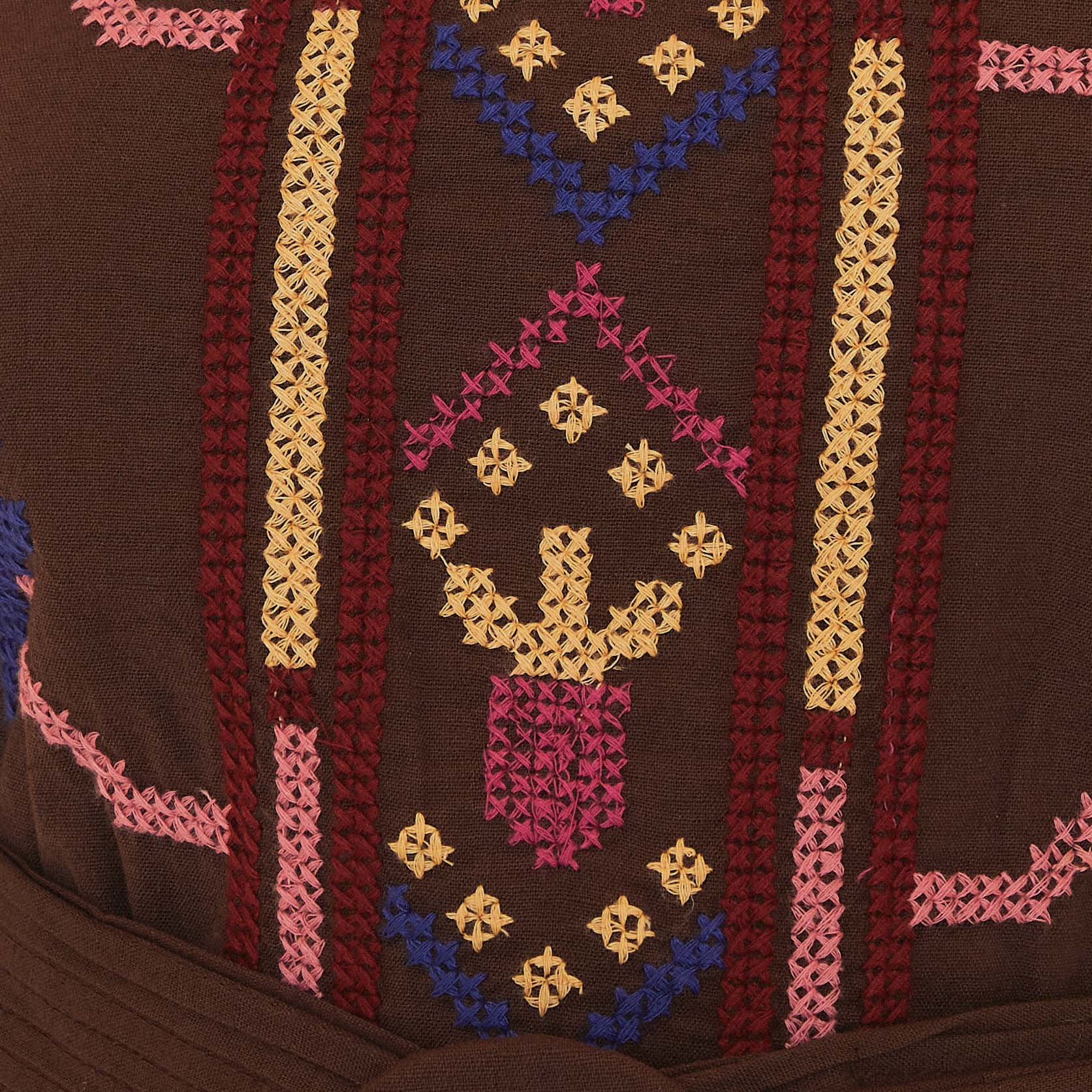 Primer plano de los bordados vibrantes en la tela del vestido.