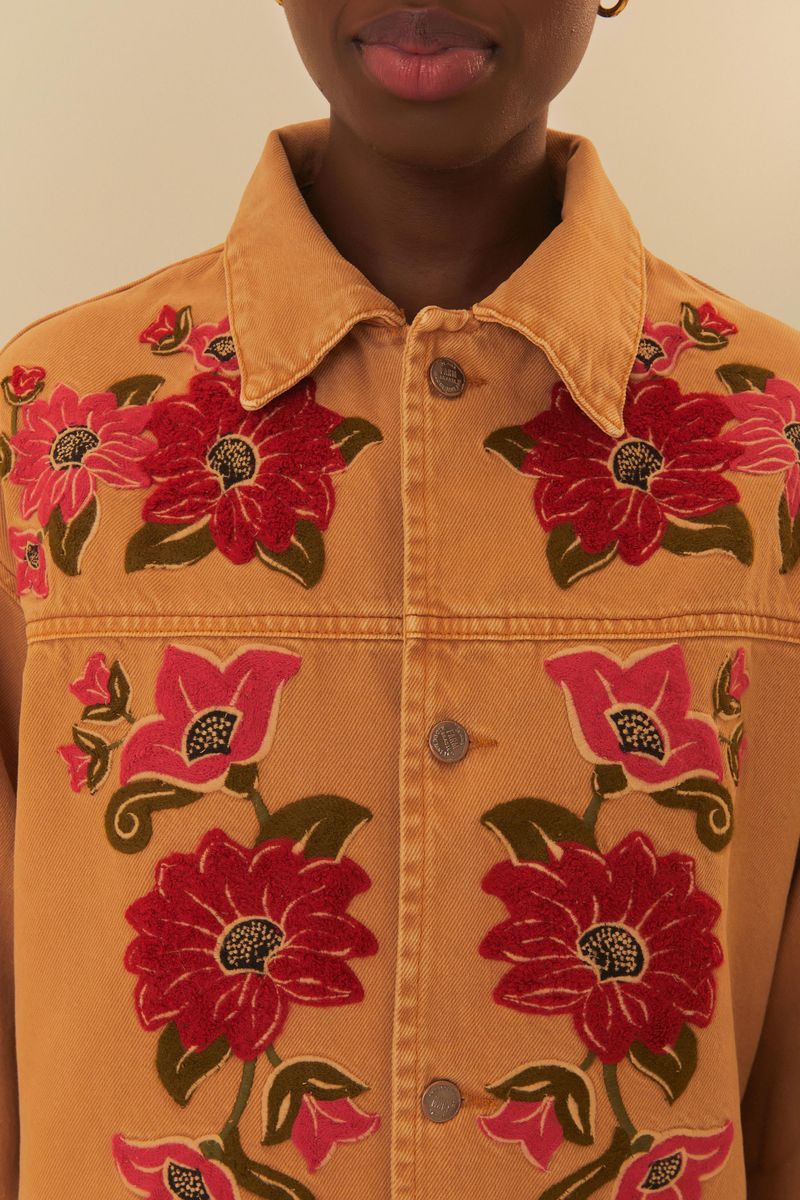 Detalle del bordado floral en la camisa de sarga, destacando los colores vibrantes.