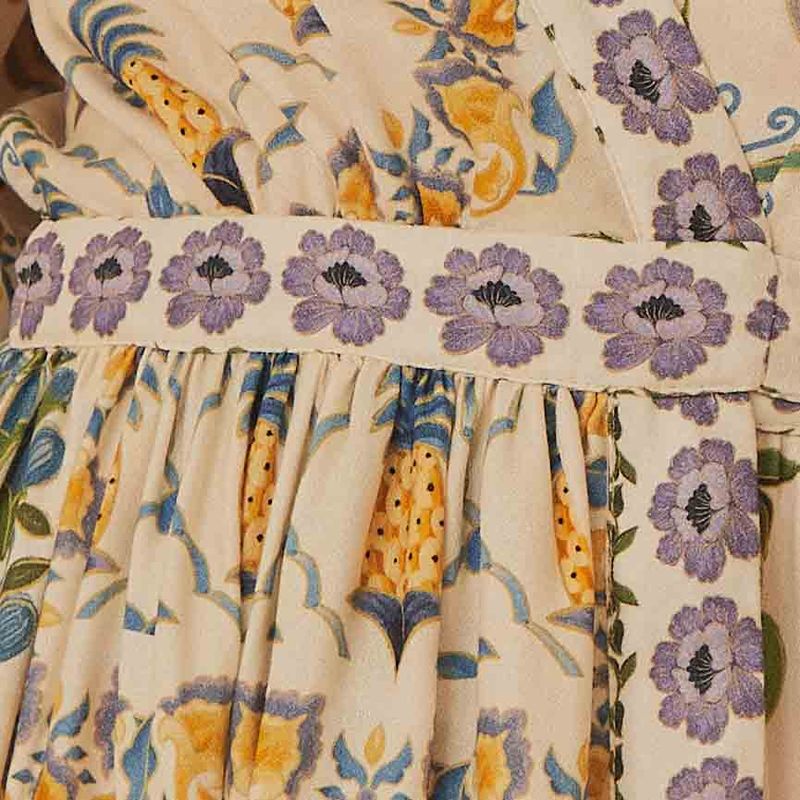 Close-up del tejido del vestido destacando los elementos florales y el acabado detallado.