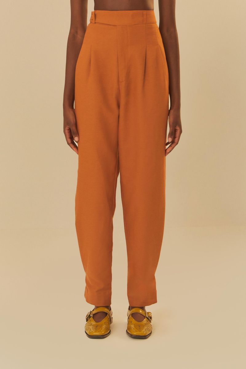 Detalle-frontal-del-pantalon-estilo-zanahoria-en-tono-ocre-mostrando-pliegues-y-cintura-alta.
