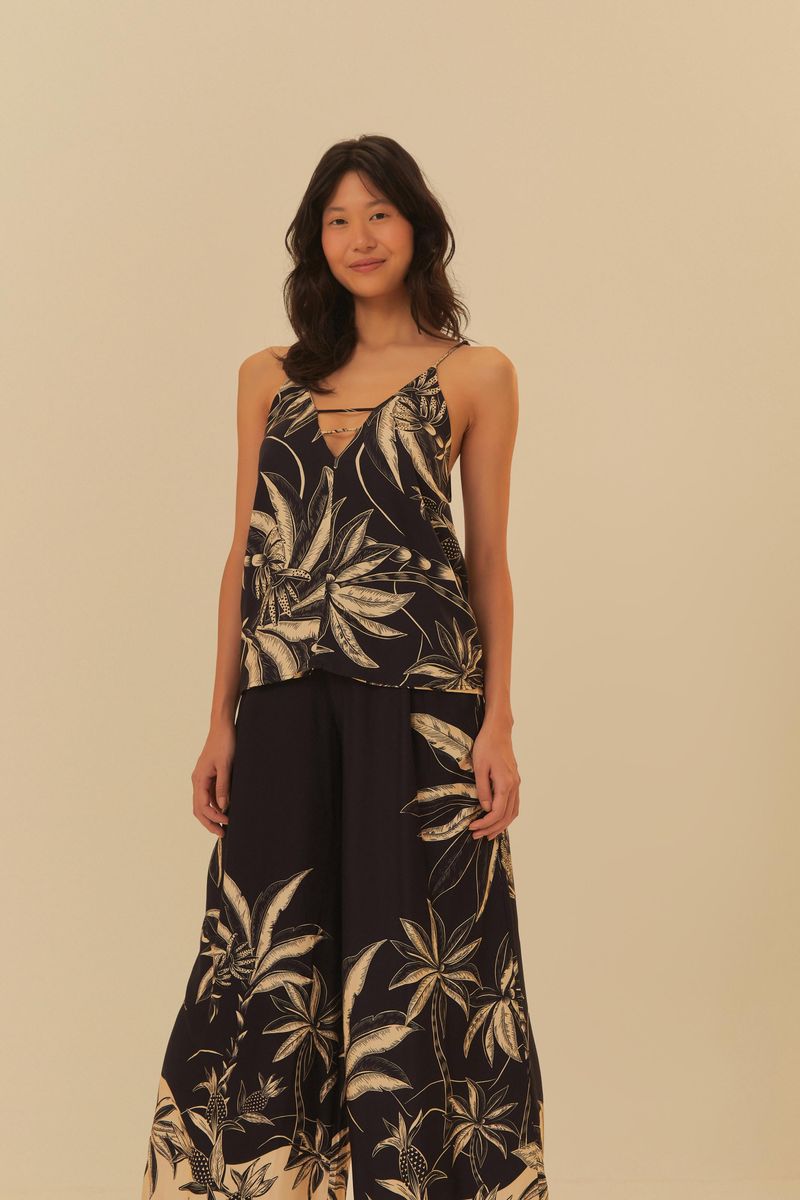 Modelo usando pantalón transpasse floresta praiana con blusa a juego, en fondo neutro.