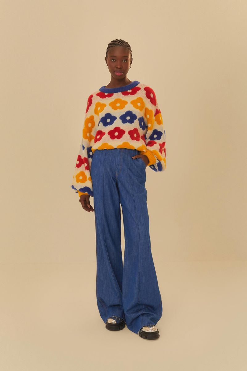 Modelo usando pantalón jean azul con suéter estampado