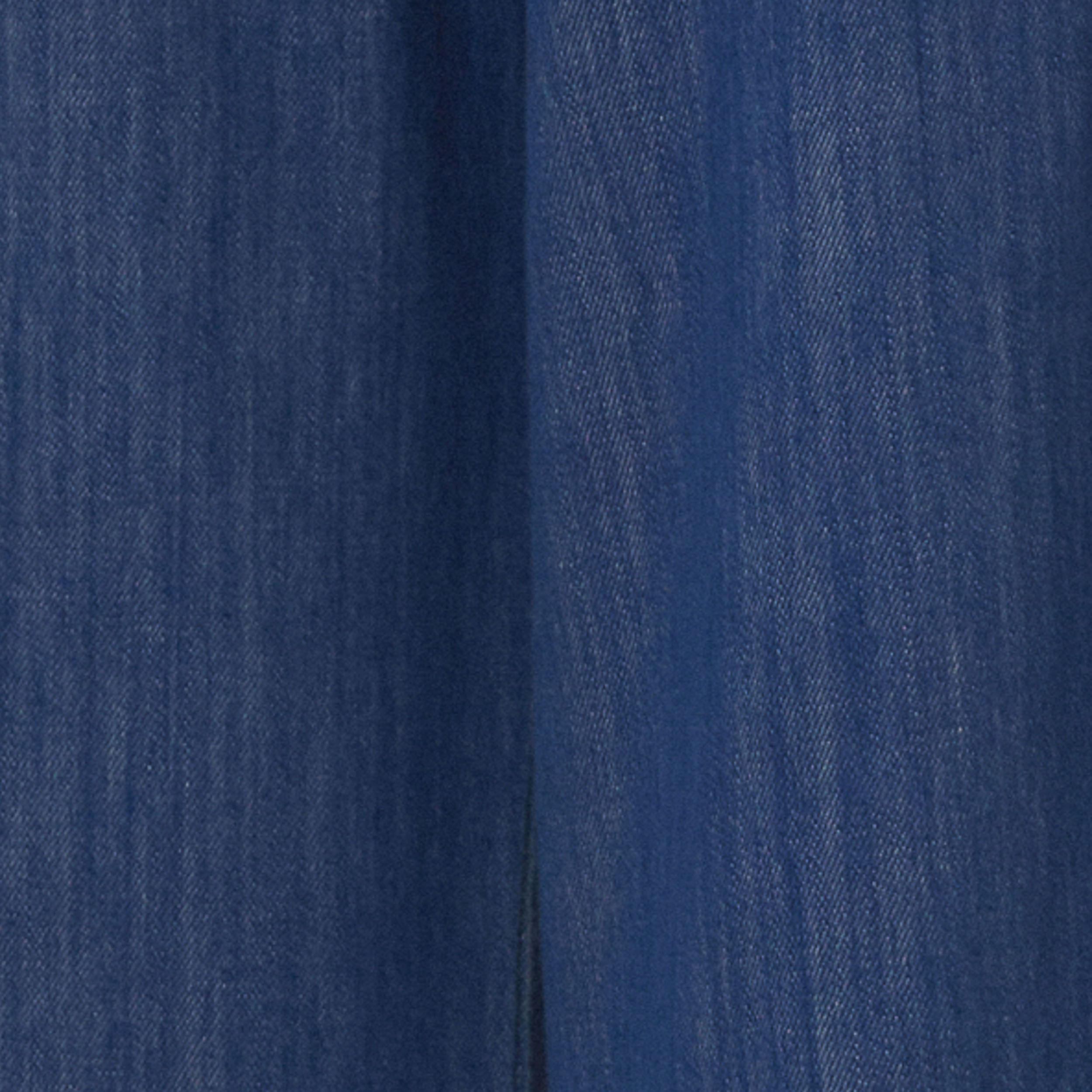 Detalle del tejido del pantalón jeans azul mostrando la textura y el tono clásico