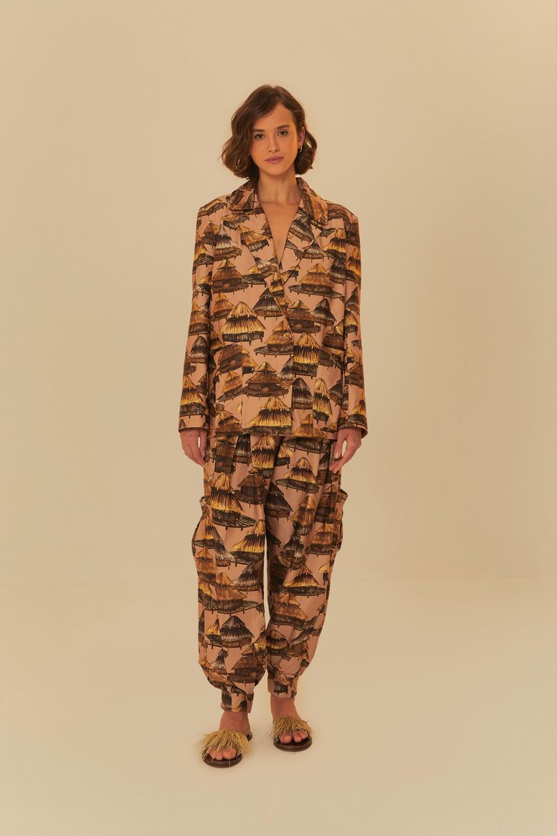Modelo-usando-un-conjunto-de-pantalon-y-blazer-estampado-con-un-tema-tropical-sobre-un-fondo-neutro.