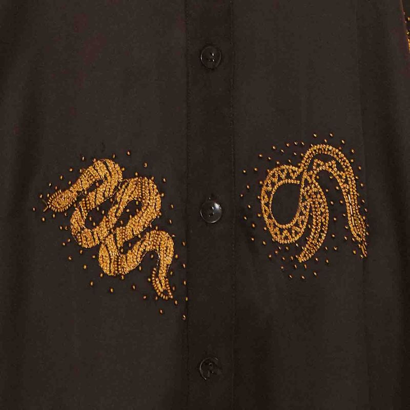 Imagen-detallada-del-bordado-dorado-de-serpiente-en-el-pantalon-negro.