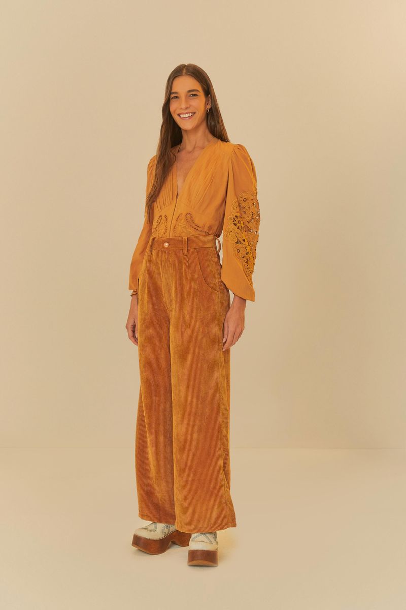 Modelo usando pantalón sastre cotele ocre, mostrando un look completo con blusa a juego y zapatos de plataforma.