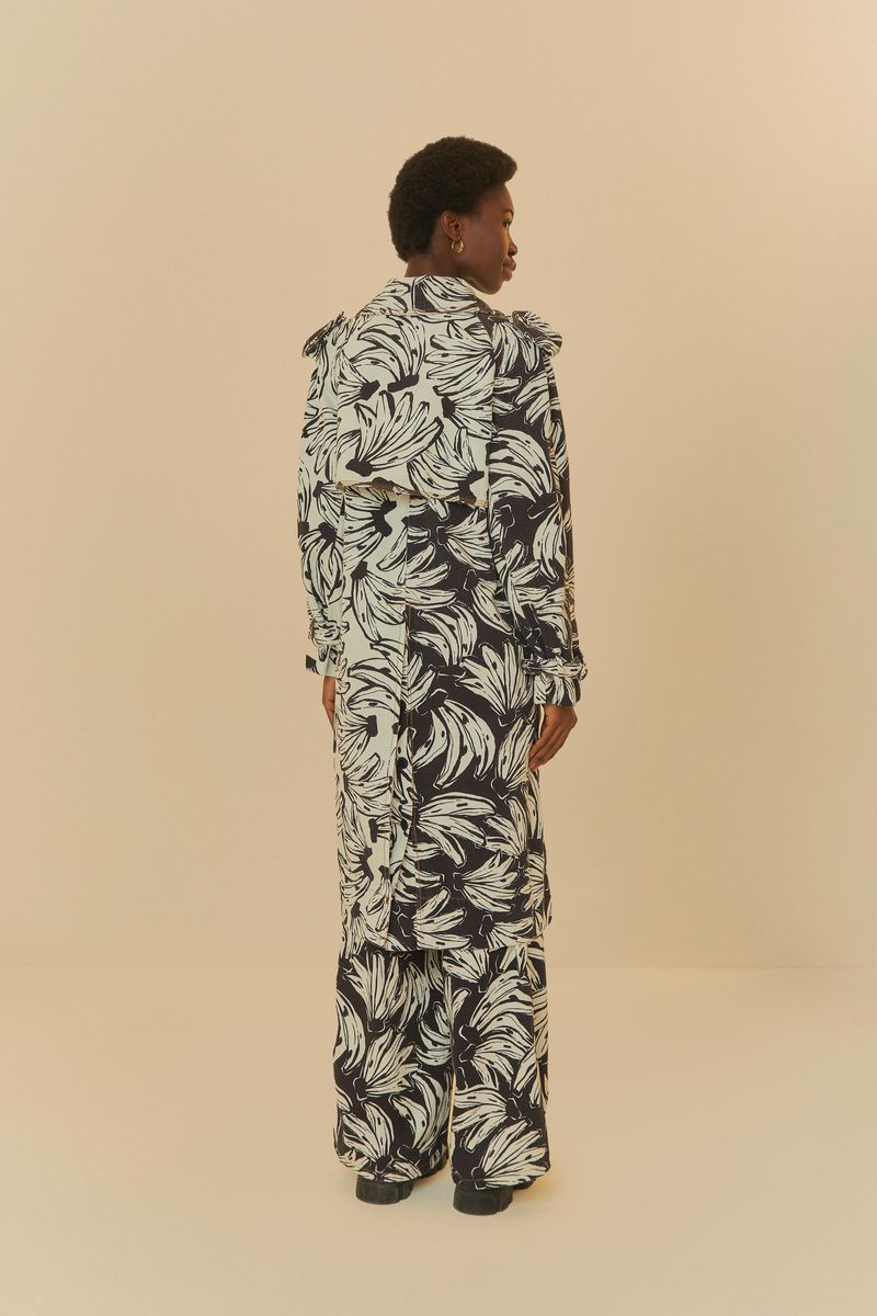 Vista trasera de trench coat estampado con diseño botánico en negro y blanco.