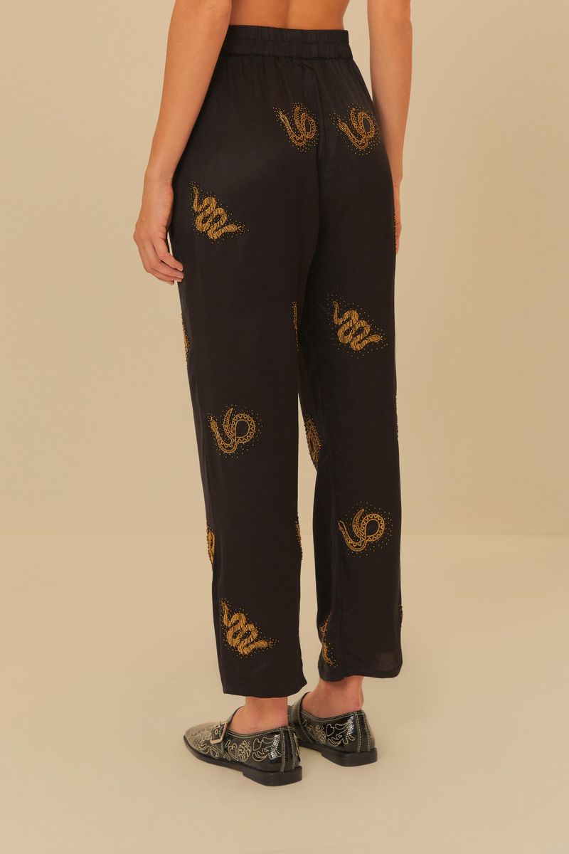 Vista-lateral-del-pantalon-negro-con-bordados-dorados-de-serpiente.