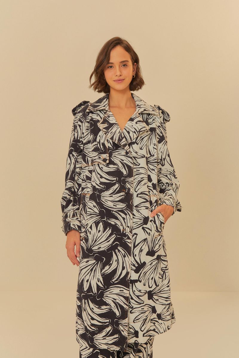 Vista frontal de trench coat con estampado de hojas y bananas en negro y blanco.