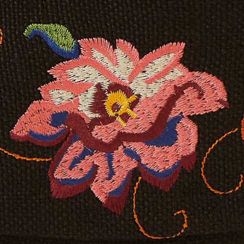 Primer-plano-de-los-bordados-florales-en-la-mochila-de-yute-negra.
