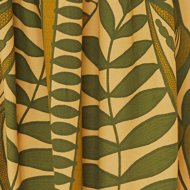 Close-up del estampado botánico en verde y amarillo de la falda.
