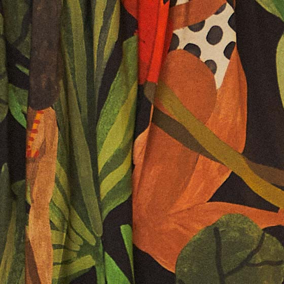 Detalle del estampado tropical con hojas y pájaros en el vestido.