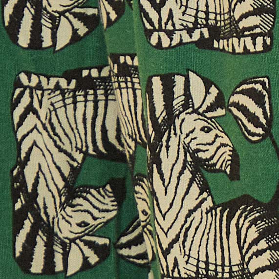 Detalle-del-estampado-de-cebra-sobre-fondo-verde-oscuro-del-pantalon-Zebrina.