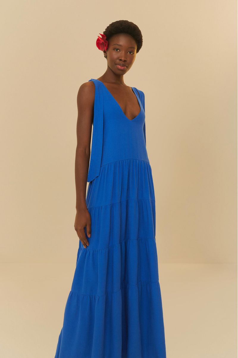 Vestido azul largo con escote en V y tirantes delgados ajustables, mostrado en un fondo neutro.