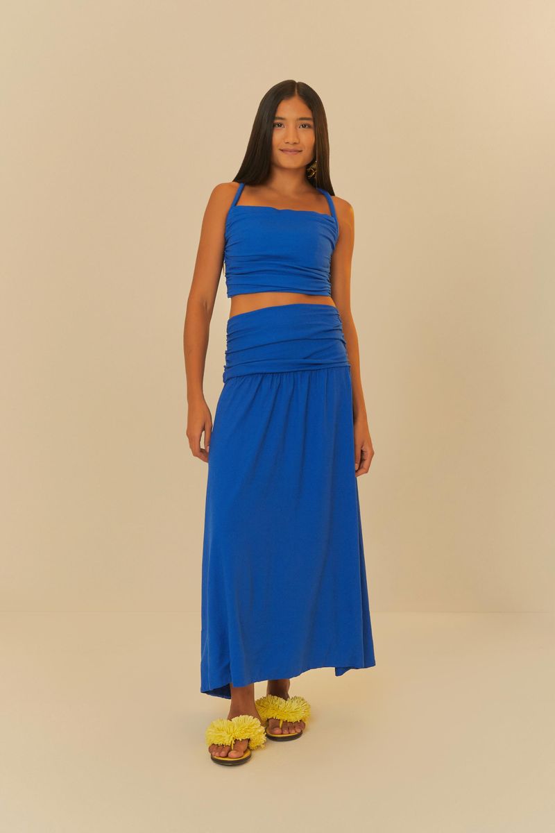 Modelo usando blusa azul con falda larga combinando, vista completa.