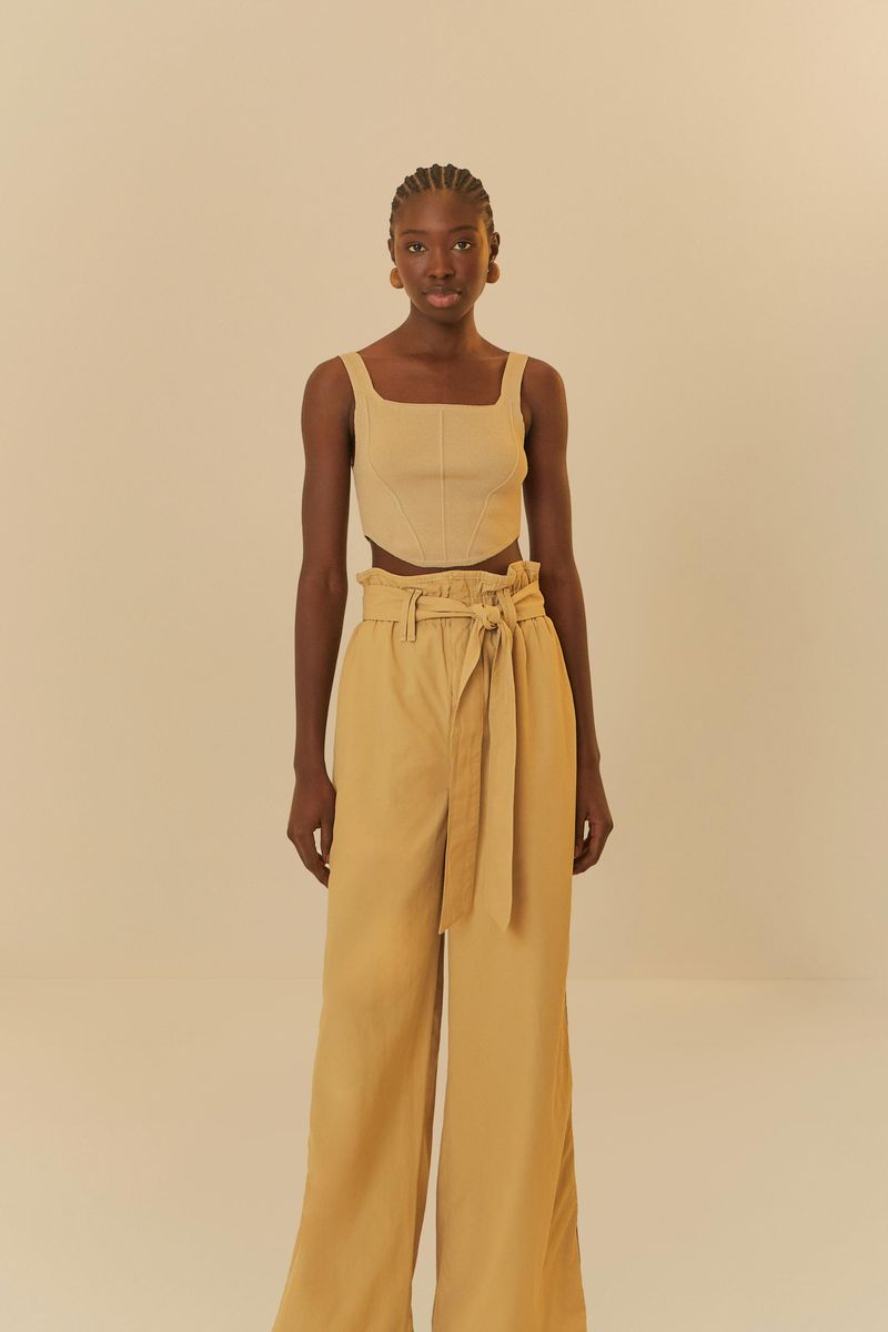 Modelo usando pantalón cinta ajustable beige, vista frontal.