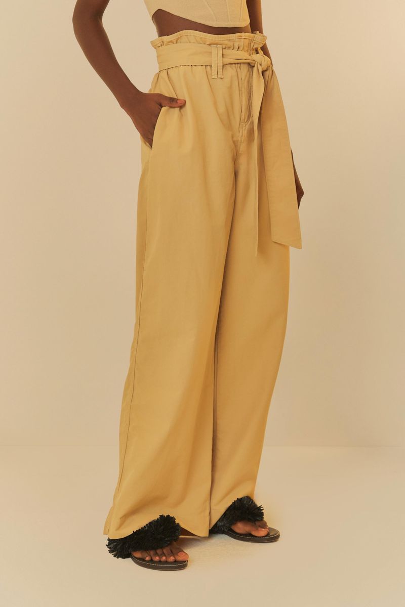 Modelo usando pantalón cinta ajustable beige, vista lateral.