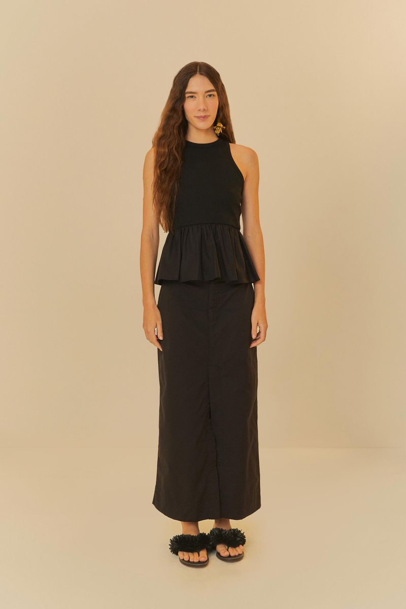 Modelo usando falda larga negra con diseño recto y largo maxi, vista completa.