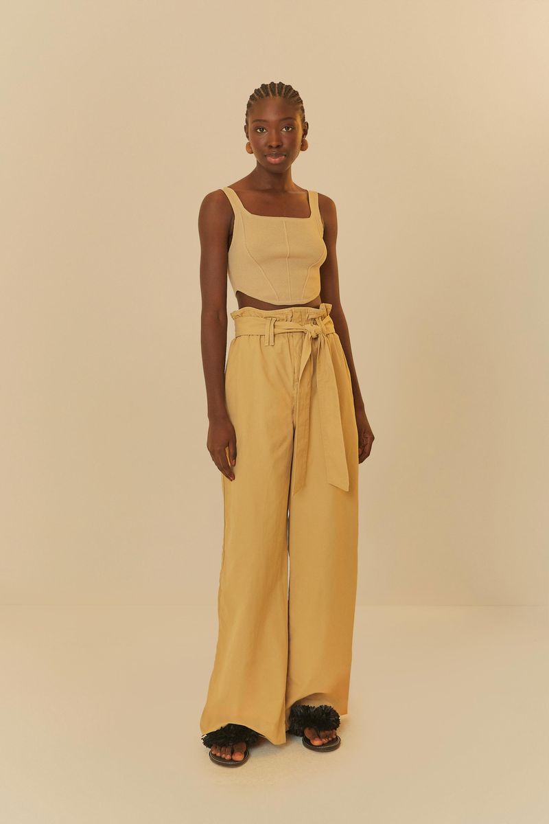 Modelo usando pantalón cinta ajustable beige, vista posterior.
