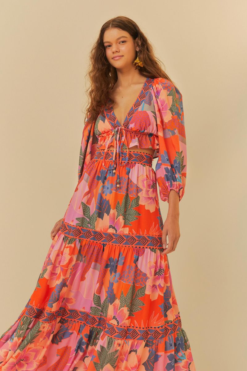 Falda midi estampada con motivos florales y botánicos, vista frontal con detalles de volantes.