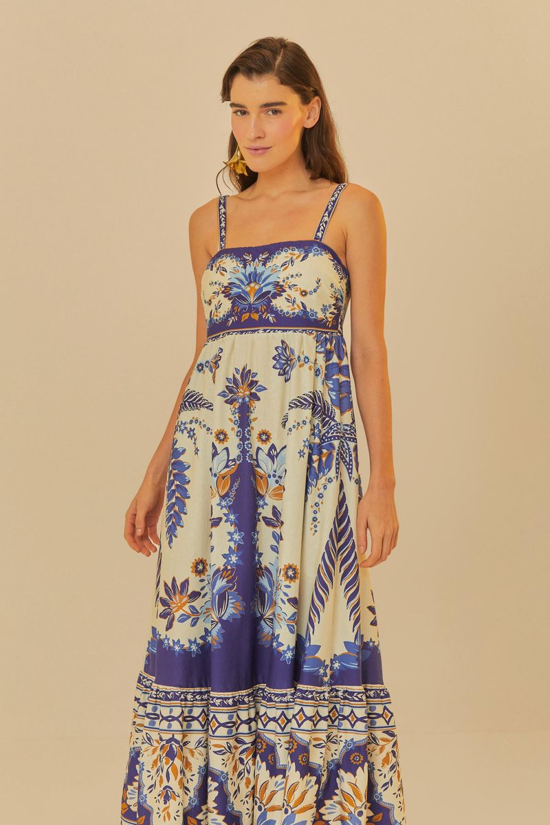 Vestido midi estampado con diseño tropical sobre fondo claro, con tirantes finos y escote cuadrado.