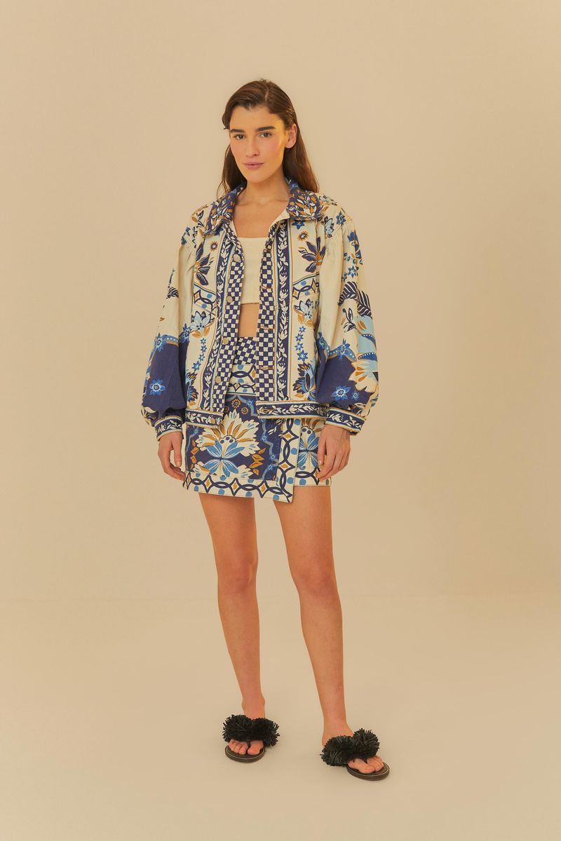 Modelo usando falda corta de sarga con estampado tropical vibrante y chaqueta combinada.