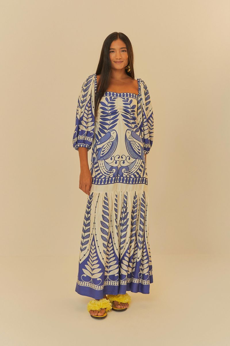 Vestido largo con estampado botánico azul y blanco, escote cuadrado y mangas abullonadas.