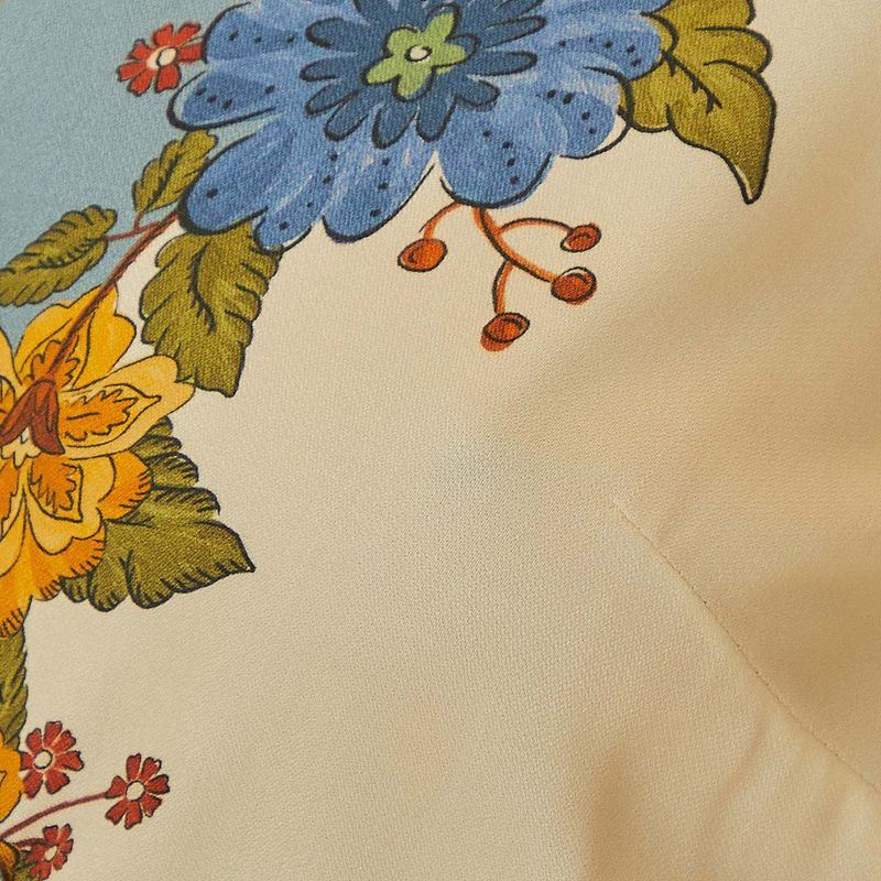 Acercamiento al estampado floral del vestido, con flores en tonos de azul y amarillo.