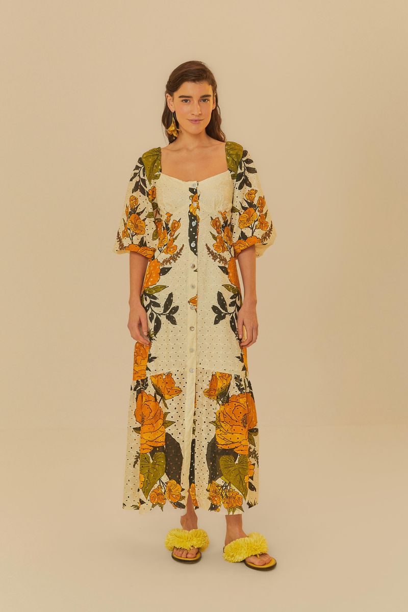 Vestido largo con estampado de flores vibrantes y detalles en tela bordada, mostrado de frente.