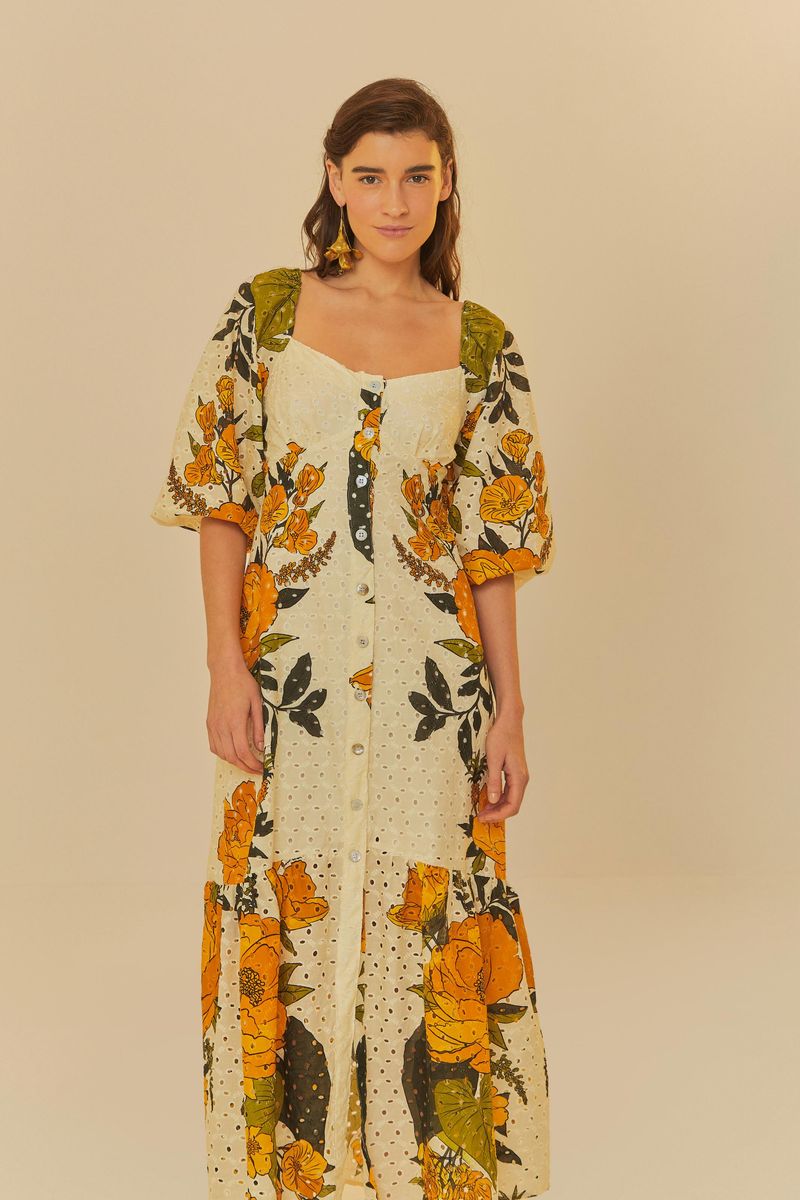 Vestido largo con estampado de flores vibrantes y detalles en tela bordada, mostrado de lado.
