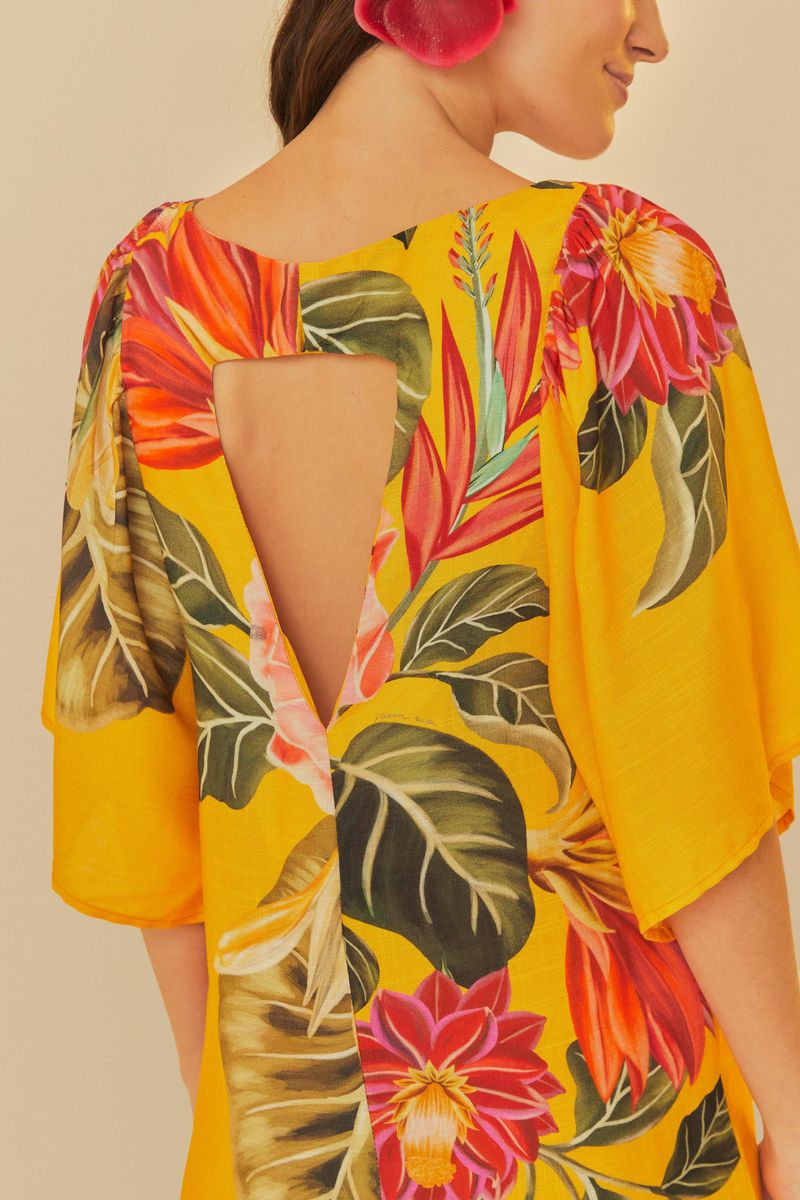 Vista trasera del vestido mostrando el detalle del escote en forma triangular y diseño floral.