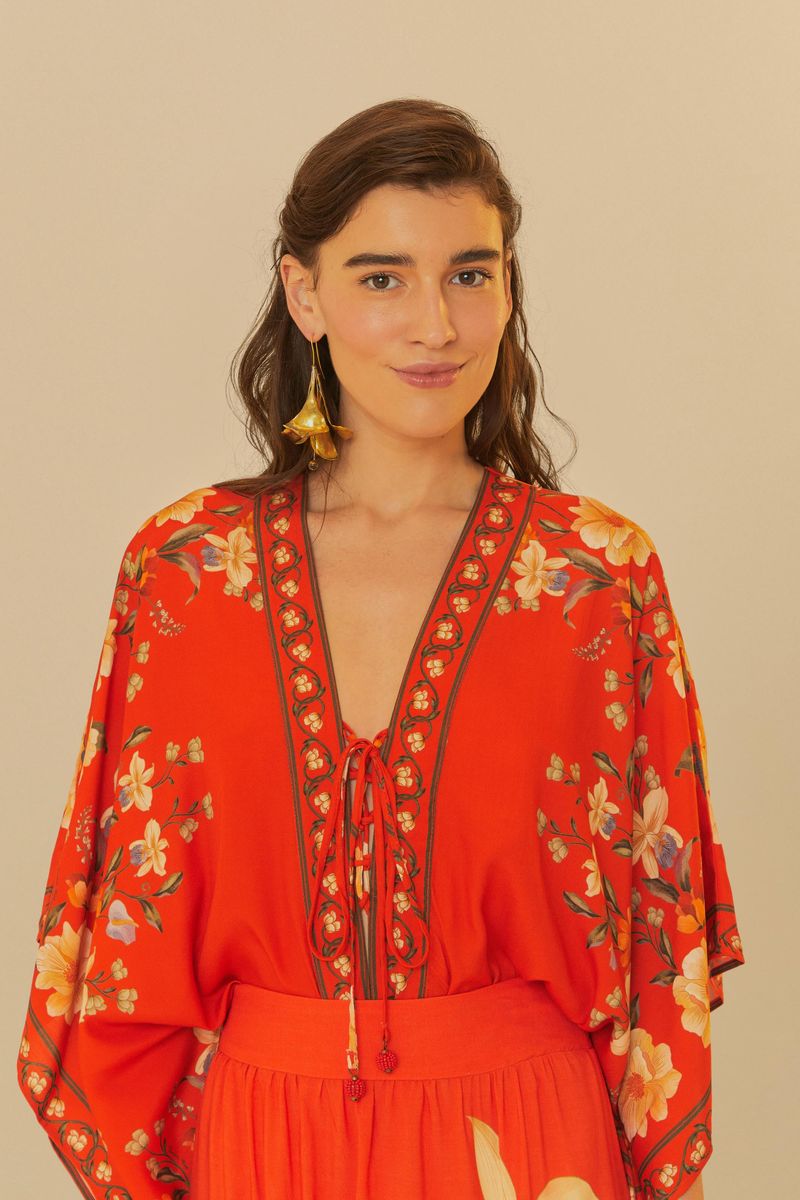 Modelo vistiendo body rojo con estampado floral y escote en V.
