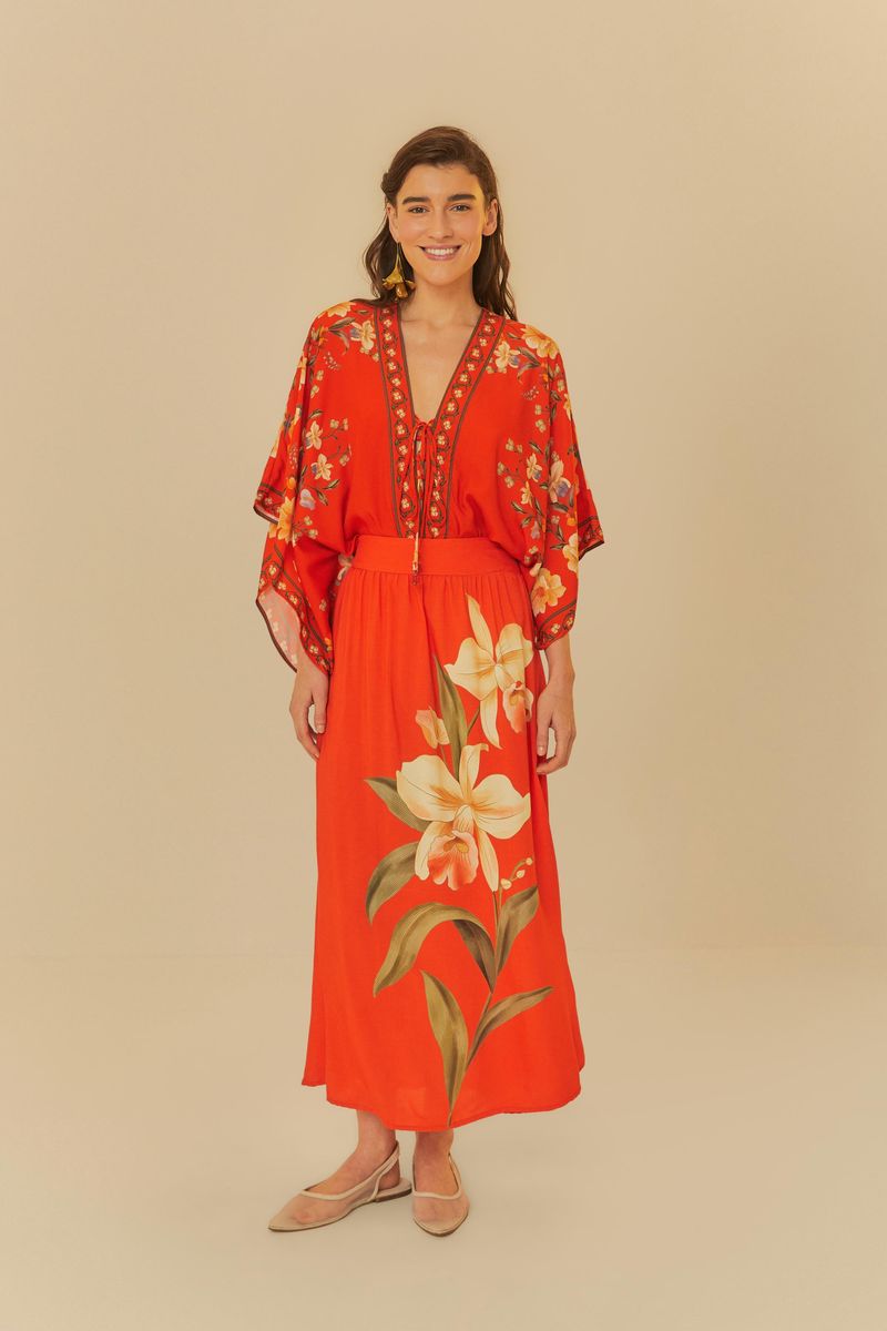 Modelo de pie usando body rojo floral con falda larga combinando.