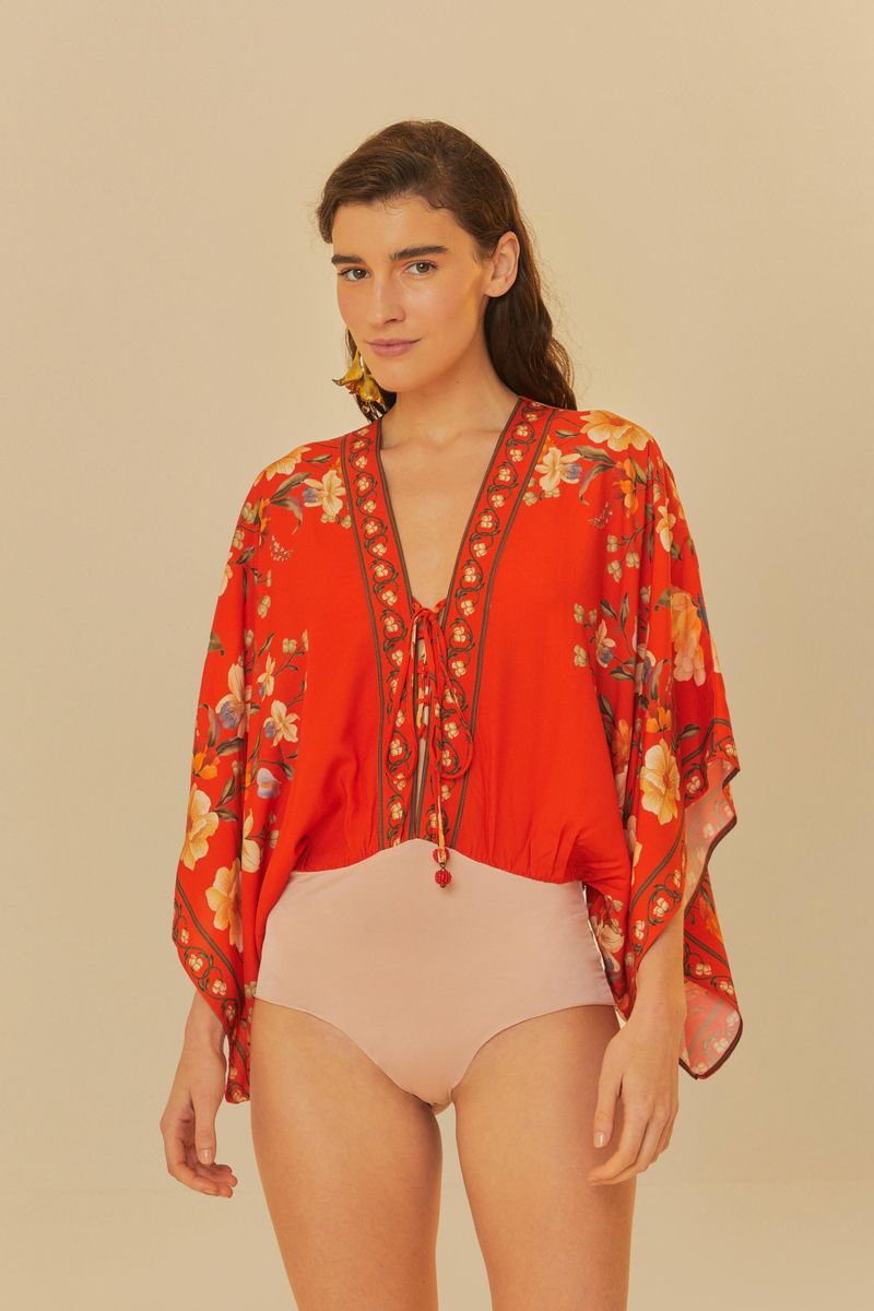 Acercamiento al body rojo floral con detalles de cordón en el escote.