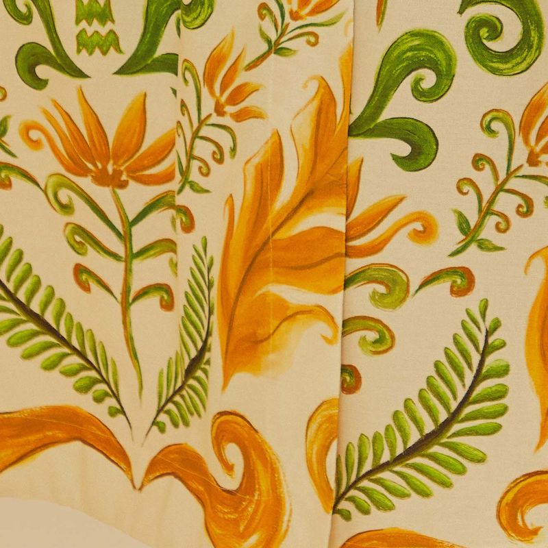 Primer plano del estampado botánico de la falda cruzada Milani, destacando elementos en verde y naranja.
