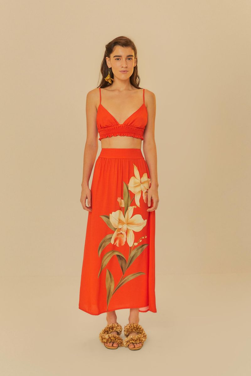 Conjunto con top rojo y falda larga estampada, visto de cuerpo entero.