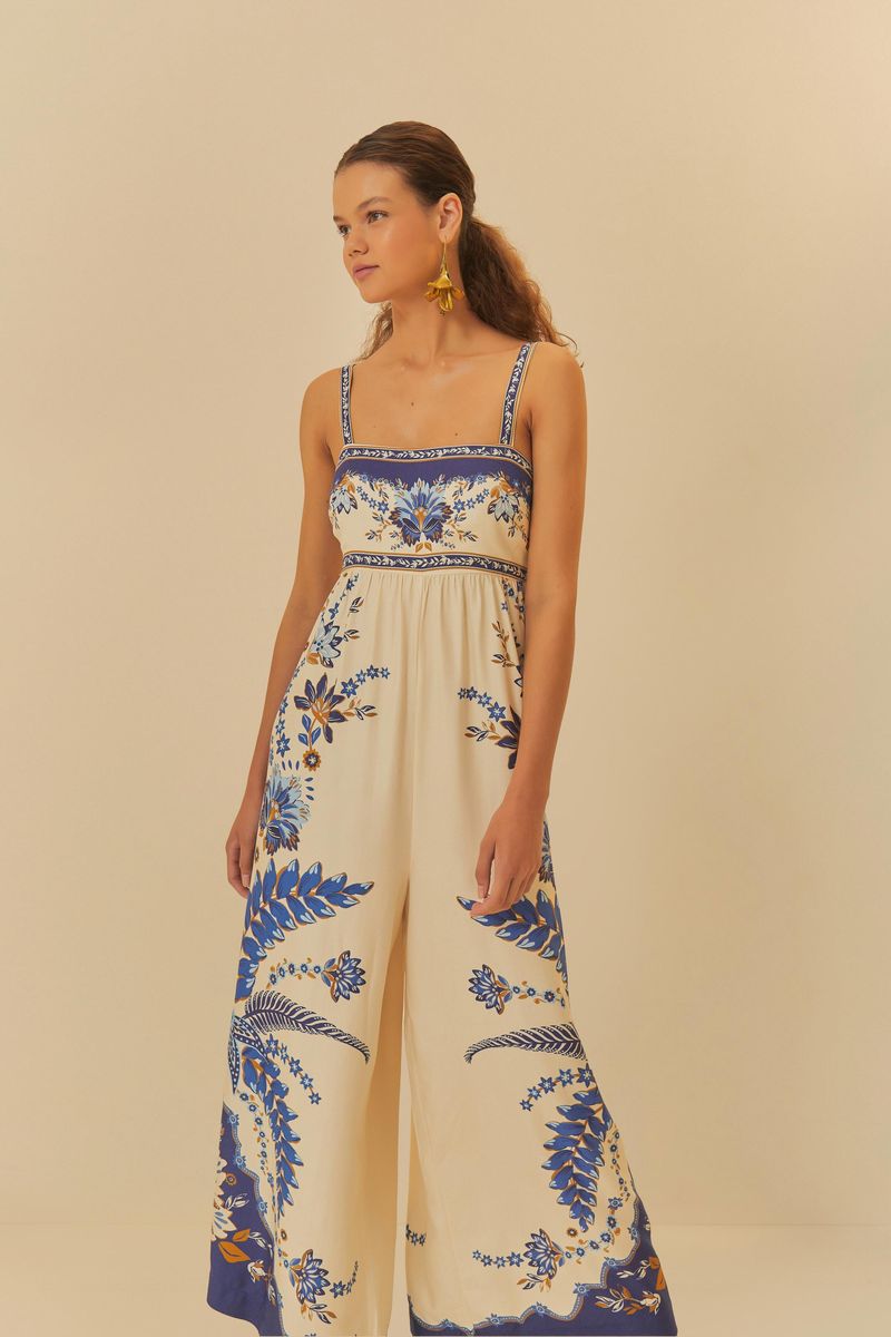 Modelo usando macacão Encanto Tropical com estampado azul e beige, vista frontal.