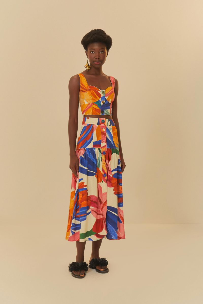 Modelo usando un conjunto colorido con estampado abstracto, que incluye un top cropped y una falda midi.