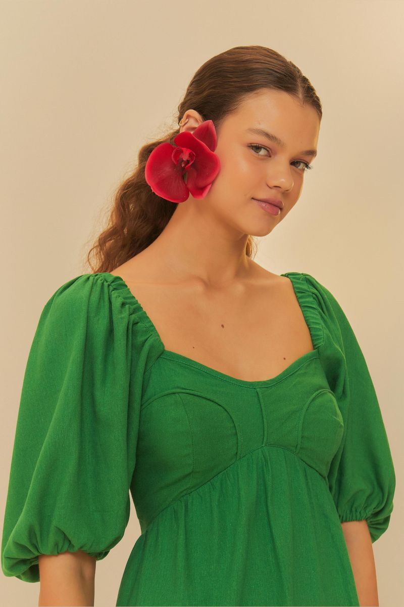 Primer plano del vestido verde que muestra el escote corazón y los detalles de las mangas abullonadas.