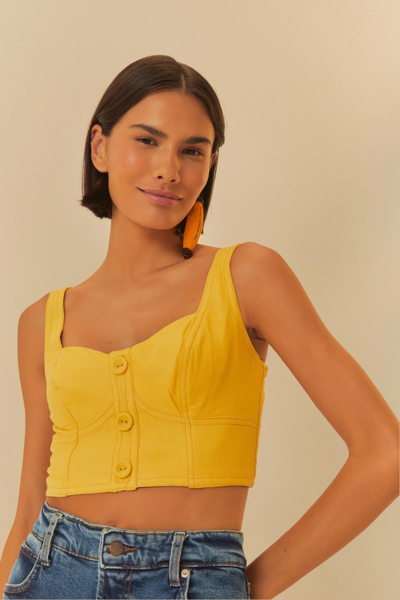 Vista lateral de la blusa amarilla con tirantes anchos.