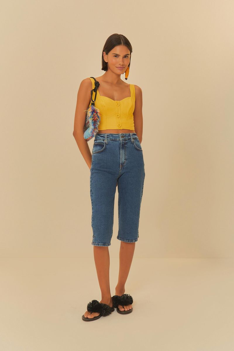Modelo luciendo la blusa amarilla con jeans y sandalias.