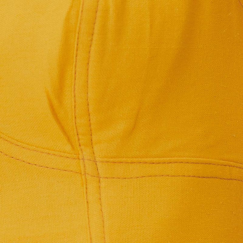 Primer plano del tejido ligero y cómodo de la blusa amarilla.