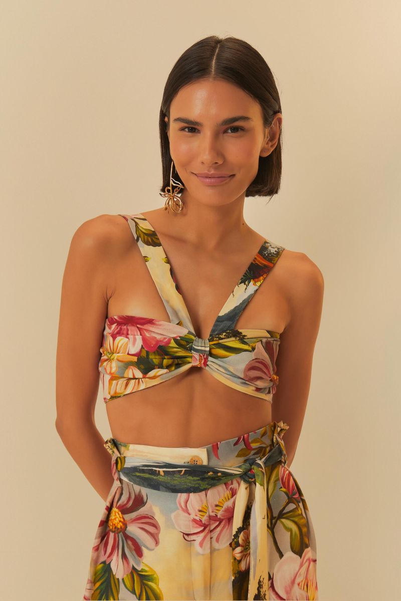 Top-cruzado-con-estampado-floral-tropical-sobre-fondo-beige-visto-de-cerca.