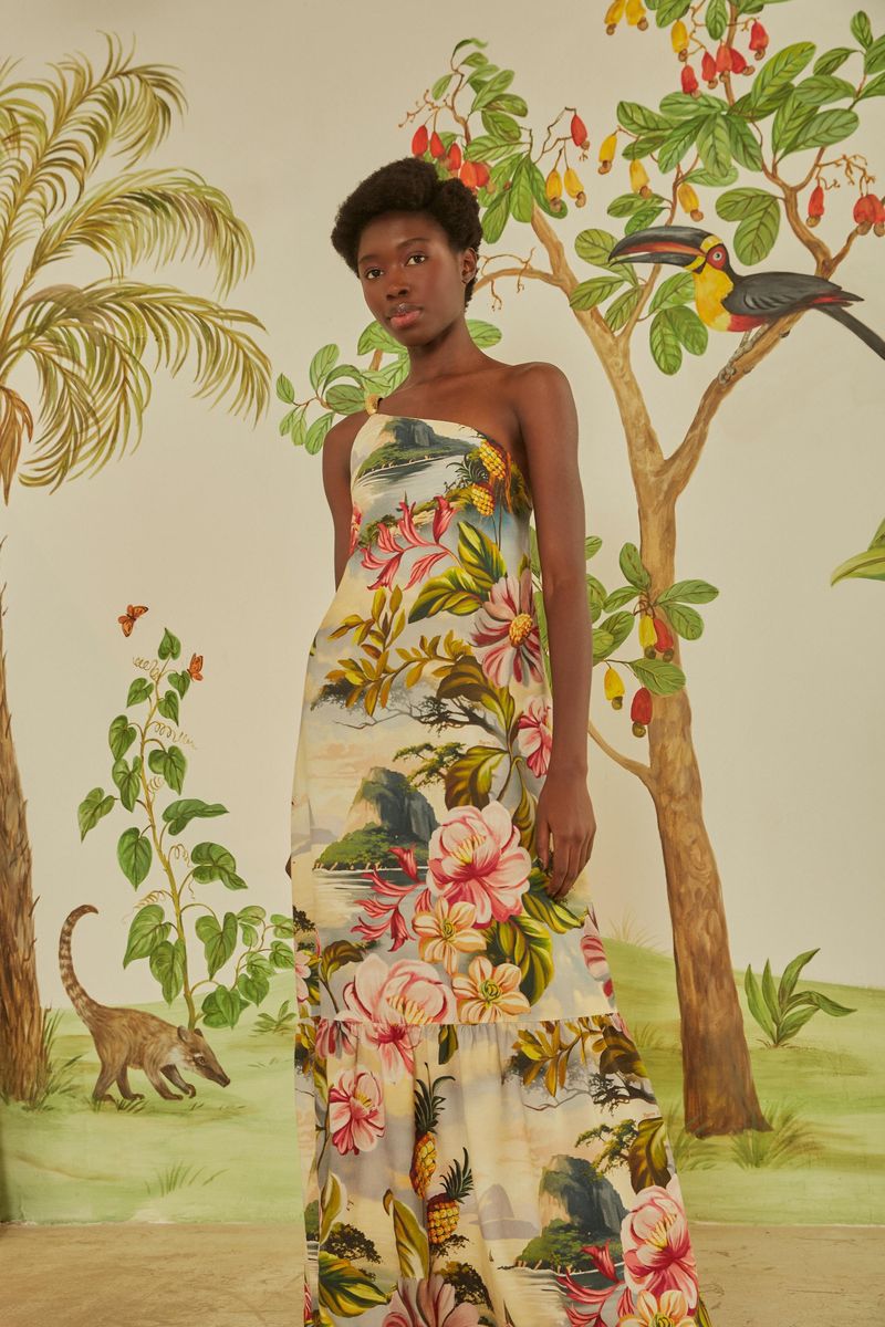 Imagen de un vestido con estampado tropical, mostrando detalles del diseño asimétrico y un solo hombro.