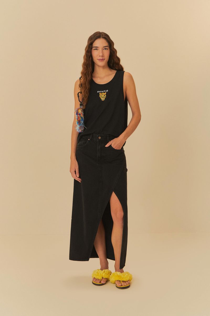 Modelo usando falda jeans midi negra con abertura frontal y blusa negra.